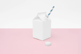 white milk packaging placed in front of a white background and on a pink floor. 