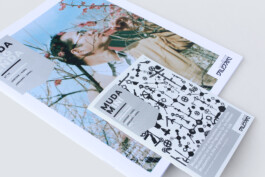 front cover of the mudam magazine which displays a man between cherry blossoms. 