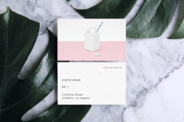 business cards placed on a marble table and palm leaves. 