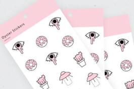 close-up of branded and illustrated stickers. stickers include: eye, doughnut and UFO. 