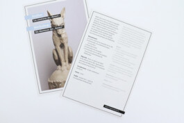 front and back of a card. the front displays a statue of a fox made out of stone. the back displays text. 